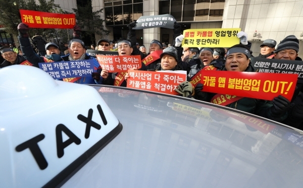 서울 개인택시운송사업조합 소속 택시기사들이 지난 14일 오전 서울 여의도 더불어민주당사 앞에서 카풀 규탄 및 생존권 사수 결의대회를 하고 있다. [뉴시스]