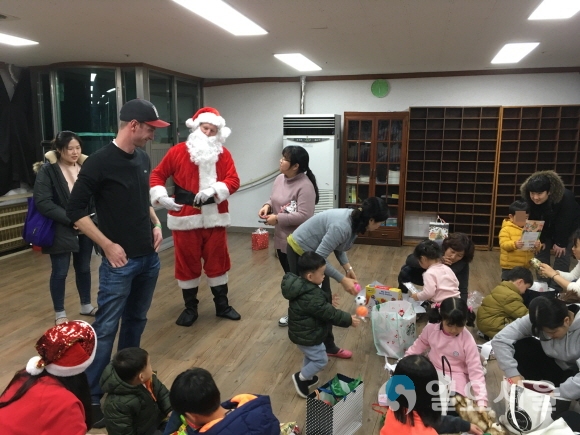 대구 거주 외국인들이 산타복장을 하고 전달한 선물을 아동보호시설의 어린이들이 각자의 선물을 열어보고 있다. 사진제공=수성구청