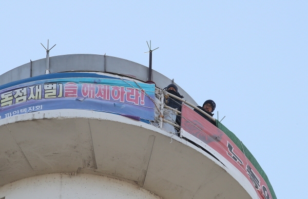 지난 11월 29일 서울 양천구 서울에너지공사 목동열병합발전소 굴뚝에서 열린 홍기탁 파인텍지회 전 지회장과 박준호 사무장이 고용 승계 약속 이행을 촉구하며 413일째 농성을 이어가고 있다. [뉴시스]