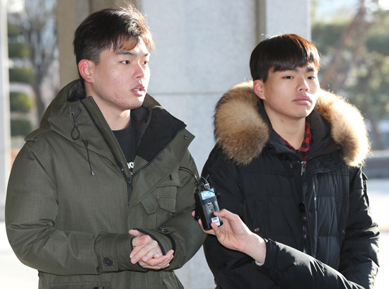 더 이스트라이트 전 멤버 이석철(왼쪽), 이승현 형제가 2일 오전 서울 서초구 서울중앙지방검찰청으로 고소인 조사를 받기 위해 출석해 취재진의 질문에 답하고 있다. [뉴시스]