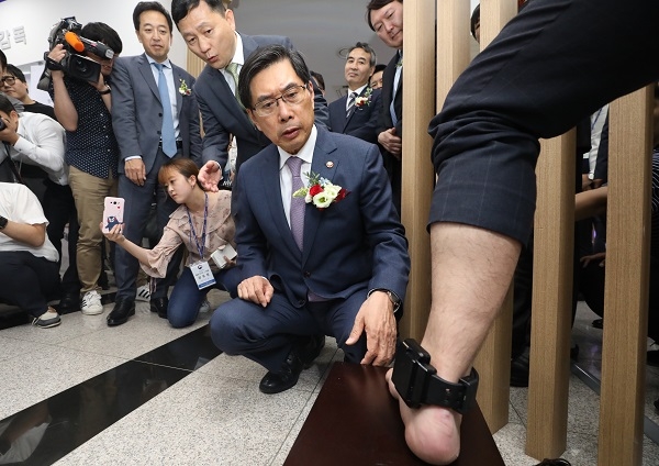 '전자감독제도 시행 10주년 기념행사'에서 박상기 법무부 장관이 최신형 전자장치(전자발찌)를 살피고 있다.  [뉴시스]