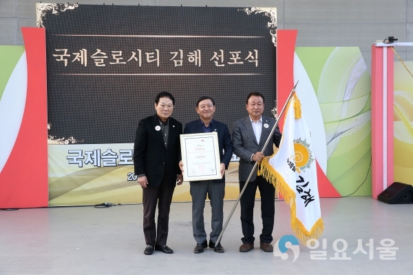 지난해 11월 3일 김해문화의전당서 열린 국제슬로시티 김해 선포식에서 손대현 한국슬로시티본부 이사장(왼쪽부터), 허성곤 김해시장, 김형수 김해시의회 의장이 슬로시티 인증서와 기를 들고 포즈를 취하고 있다. © 김해시 제공