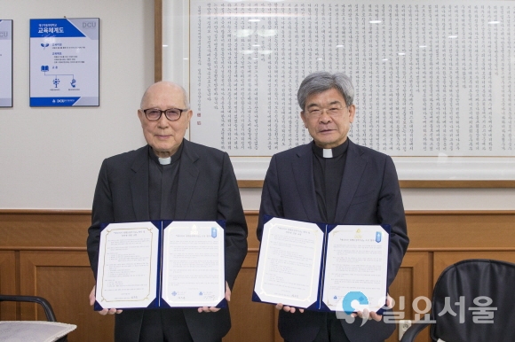 애국지사 정행돈 선생의 후손 대표 정은규 몬시뇰(왼쪽)과 김정우 대구가톨릭대 총장이 27일 ‘애국지사 정행돈 장학기금’ 조성 협약을 체결하고, 협약서를 보이고 있다. 사진=대구가톨릭대