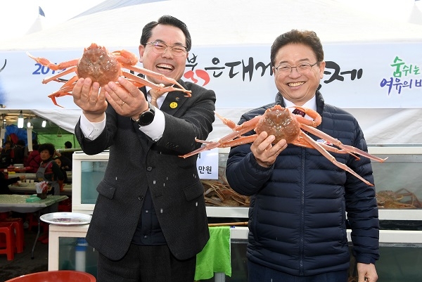 전찬걸 울진군수(왼쪽)와 이철우 도지사가 영덕대게를 들고 환하게 웃고 있다.