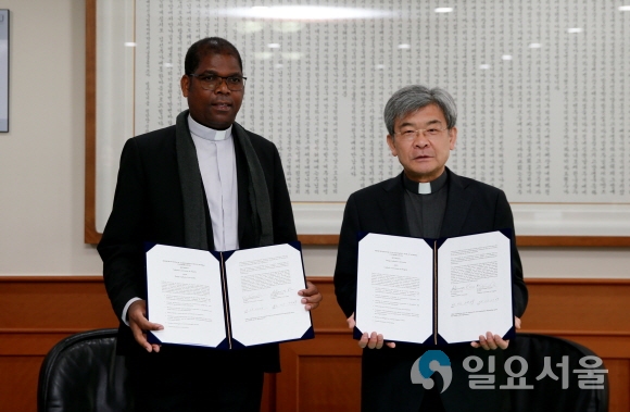 김정우 대구가톨릭대 총장(오른쪽)과 호세 비센트 카쿠치 앙골라가톨릭대 총장이 교류협약을 체결한 뒤 협약서를 보이고 있다. 사진=대구가톨릭대