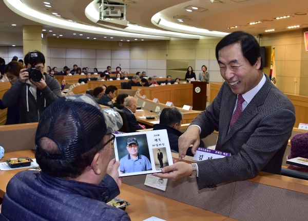 문석진 서대문구청장이 지난해 11월 9일 구청 대회의실에서 열린 ‘2018 행복타임머신 작품 전달식’에서 어르신에게 추억의 액자(왼쪽 사진)와 캐리커처(오른쪽 사진)를 전달하고 있다.