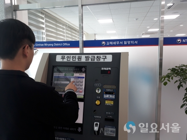 세무서를 방문한 민원인이 무인민원발급창구를 이용하여 민원서류를 발급하고 있다. © 밀양시 제공