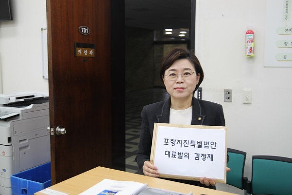 자유한국당 김정재 의원이 1일 ‘포항지진 특별법안’발의문 서류를 들고 사진을 찍고 있다.