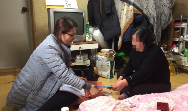 마포구 신수동의 우리동네주무관이 어려운 이웃의 가정을 방문해 복지대상자와 상담하고 있다.