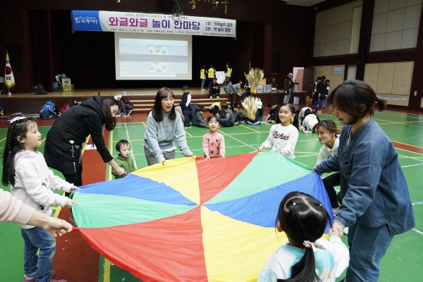 ▲지난해 열린 ‘와글와글 놀이 한마당’에서 아이들과 부모가 함께 ‘낙하산 제기’ 놀이를 하고 있다.