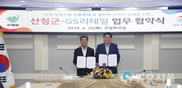 25일 산청군 군정회의실에서 산청군과 GS리테일 간 ‘지역 농식품 유통발전을 위한 업무협약’이 열린 가운데 이재근(사진 왼쪽) 산청군수와 허연수 GS리테일 대표이사가 협약서를 들고 기념촬영을 하고 있다.     © 산청군 제공