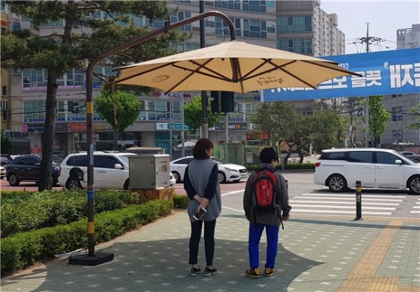 ▲동대문구 전농사거리에 설치된 ‘무더위 그늘막’에서 신호를 기다리는 주민들이 햇볕을 피하고 있다.
