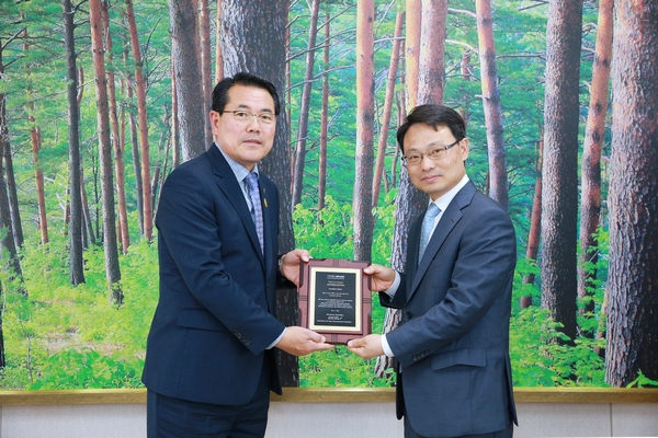 전찬걸 울진군수(우측)가 박은식 AFoCO 사무차장에게 감사패를 전달받고 기념사진을 찍고 있다.
