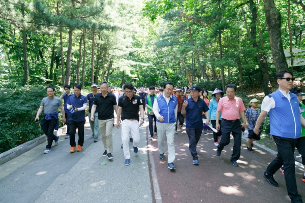 노현송 구청장(가운데 파란옷)이 신록축제에서 주민들과 함께 숲속을 걸으며 대화를 나누고 있다.