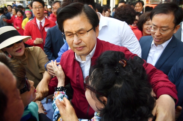 황교안 자유한국당 대표가 7일 오전 부산 중구 자갈치시장에서 '국민 속으로 민생투쟁 대장정' 출정 기자회견을 마무리한 뒤 지지자들에게 둘러싸여 울먹이고 있다. [뉴시스]