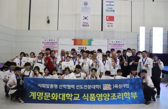 “2019 대한민국챌린지컵 국제요리경연대회”에서 수상한 학생들과 심사위원들이 파이팅을 외치고 있다.
