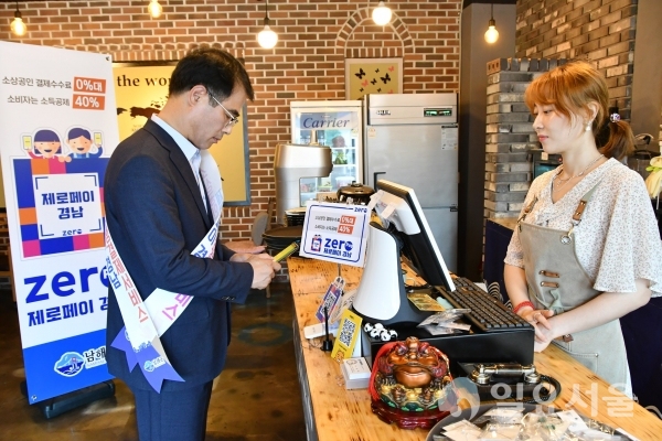 장충남 남해군수가 제로페이 가맹점에서 제로페이로 구매대금을 결제하고 있다 © 남해군 제공