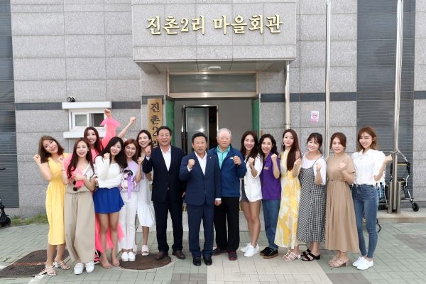 12인의 미스트롯 여신들이 백령면 진촌2리 마을회관 앞에서 장정민 옹진군수와 주민대표와 기념촬영을 하고 있다