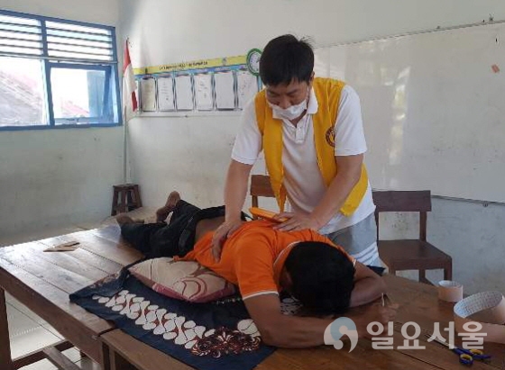 물리치료과 이재홍 교수가 인도네시아 주민들을 대상으로 도수치료를 하고 있다. 사진=대구보건대