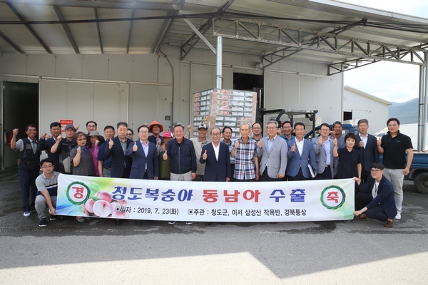 이승율 청도군수가 지난 23일 이서 삼성산작목반과 청도군 이서면 흥선리 삼성산 작목반 공동선별장에서 청도복숭아 수출 선적식을 가지고 단체사진을 찍고 있다.