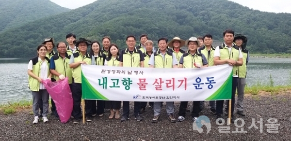 양명호 지사장을 비롯한 직원들이 봉성저수지 정화활동을 하면서 기념촬영 © 함안군 제공