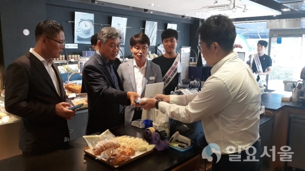 최옥환 마산회원구청장이 이성섭 농협창원시지부장과 함께 제로페이 가맹점에서 창원사랑상품권으로 결제 시연하고 있다.