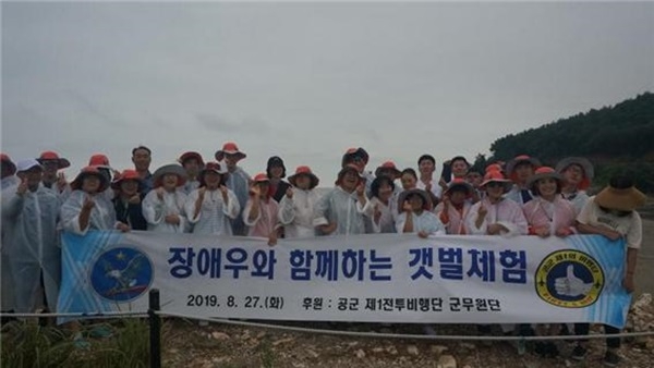 ▲지난 27일 공군 제1전투비행단 군무원단은 부대인근 시온장애인보호작업장 장애인 30명을 대상으로 조개잡이 및 염전체험을 하는 ‘사랑나눔 행사’를 실시했다.(사진제공=공군 제1전투비행단)