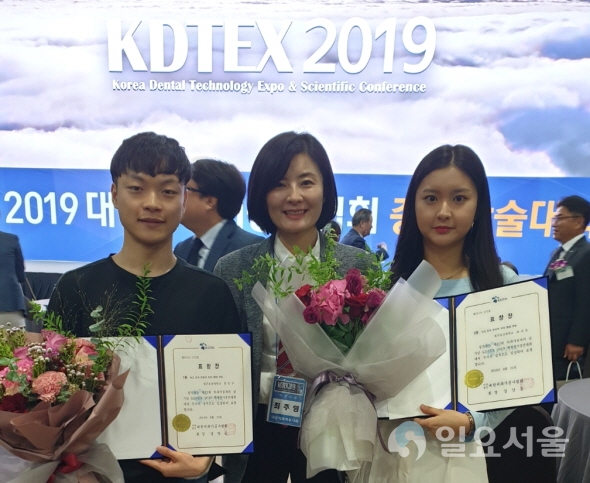 24일 대구 EXCO‘KDTEX 2019’에서 개최된 전국 치기공과 학생실기 경진대회에 치아형태 석고조각 부문 최우수상과 우수상을 나란히 수상한 대구보건대학교 치기공과 3학년 전민구·최지윤 학생이(왼쪽·오른쪽)와 최주영 지도교수(가운데)와 함께 기념촬영을 하고 있다. 사진=대구보건대