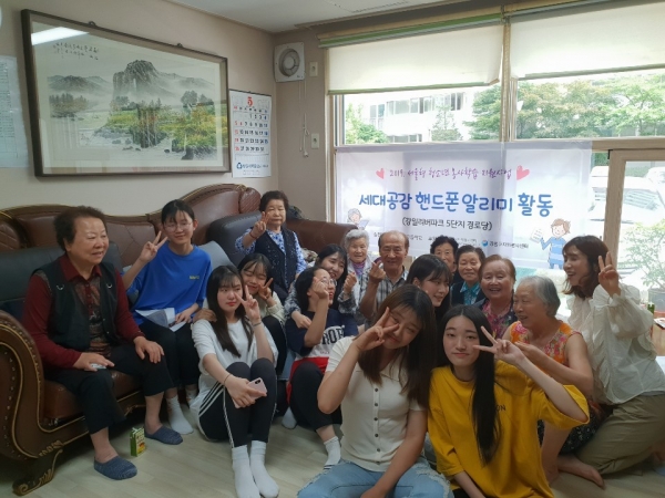 명일여자고등학교 학생들이 지역 어르신사랑방을 찾아가 어르신들께 핸드폰 사용방법을 알려드리고, 단체사진을 촬영했다.