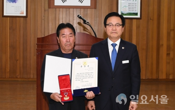 1일, 창녕군청 대회의실에서 故정용백님의 장남 정영철씨가(사진 좌측) 무공훈장을 전수 받고 한정우 군수와(사진 우측) 기념촬영을 하고 있다. @ 창녕군 제공