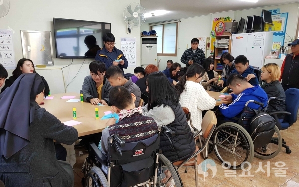 진전문대 사회복지과 학생들이 5일 대구 북구 상록장애인주간보호센터를 찾아 이곳 장애인들을 대상으로‘종이접기’ 봉사활동을 펼치는 모습. 사진제공=영진전문대