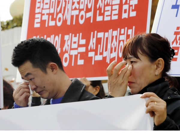 북한인권단체총연합의 탈북자들이 12일 서울 종로구 정부서울청사 앞에서 '귀순 탈북자 강제추방 규탄' 기자회견 중 눈물을 흘리고 있다. [뉴시스]