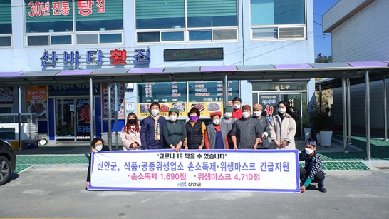전남 신안군이 식품 공중위생업소에 손소독제와 위생마스크를 지원하고, 기념으로 사진을 촬영하고 있다.