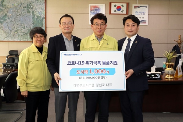 ▲13일 오전 김종효 광주광역시 행정부시장이  행정부시장실에서 코로나19 위기극복 기부금품 기탁식에 참석해 정선교 대명푸드시스템 대표로부터 도시락 1000개를 전달받은 후 기념촬영을 하고 있다.(사진제공=광주광역시)