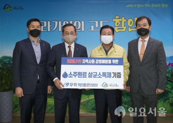 ㈜무학 이수능 대표이사(좌에서 두번재)는 24일, 함안군(조근제 군수 좌에서 세번째)을 방문해 '코로나19' 예방을 위해 사용해달라며 500ml 살균소독제 1000개를 기탁했다. @ 함안군 제공