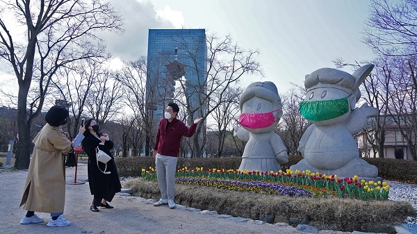 코로나19를 피해 경주엑스포를 방문한 관광객들이 미스크를 착용한 마스코트 화랑과 원화 앞에서 사진촬영을 하며 즐거워 하고 있다.