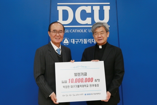 박정한 전 부총장(사진 왼쪽)이 김정우 총장에게 발전기금을 전달하고 있다.