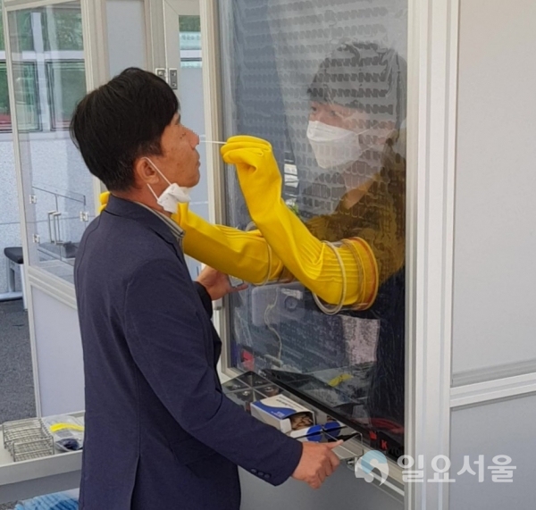 지난 22일 창녕군 보건소 앞에 설치한 워킹스루 부스에서 검체 채취를 하는 모습이다. @ 창녕군 제공