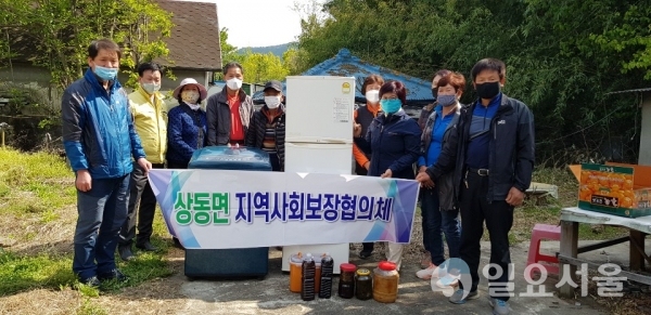 지난 24일, 상동면 지역사회보장협의체는 지역의 한 수급자에게 세탁기와 냉장고, 된장, 고추장 등을 전달했다.(오른쪽 4번째 유동선 상동면 지역사회보장협의체 위원장) @ 밀양시 제공