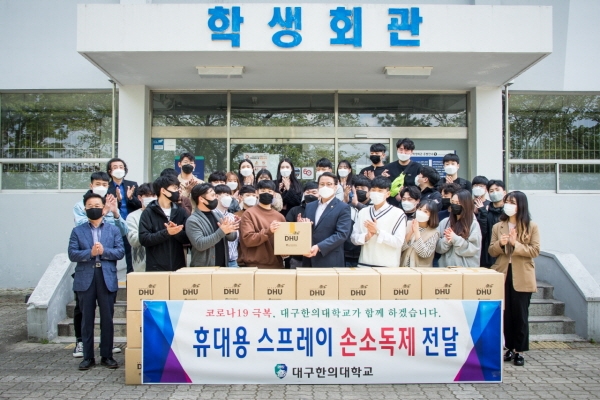 변창훈 총장은 27일 학생회관에서 이재익 총학생회장에게 재학생 전원에게 지급할 휴대용 스프레이 손소독제를 전달하고 있다