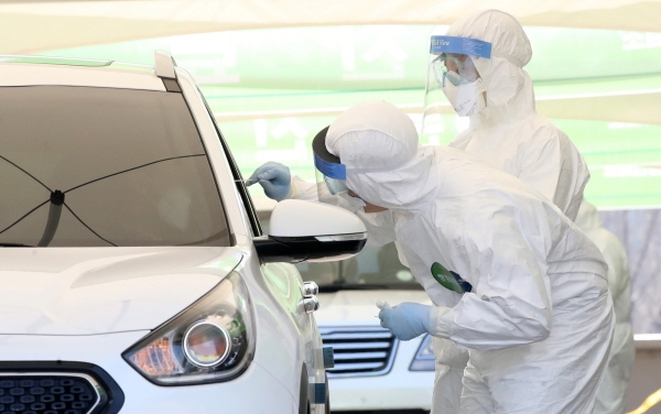 의료진들이 지난 3월24일 서울 송파구 잠실주경기장에 마련된 드라이브 스루 신종 코로나바이러스 감염증(코로나19) 선별진료소에서 차량에 탑승한 시민을 검사하고 있다. [뉴시스]