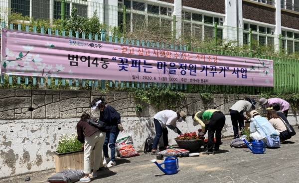 범어4동 통우회가 경동초등학교 골목에 꽃길을 조성하고 있다.