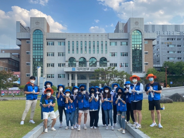대구과학대학교 캠퍼스 지킴이 학생들이‘덕분에’수화 자세를 취한 채로 단체사진을 찍고 있다.