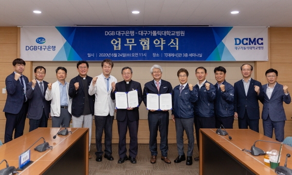 협약서 들고 단체사진 촬영 중인 송재준 대구가톨릭대의료원장(가운데-왼쪽)과 김태오 대구은행장(가운데-오른쪽), 그리고 양 기관 주요 관계자들.