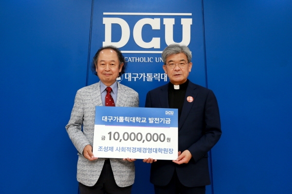 조성제 대구가톨릭대 사회적경제경영대학원장이 김정우 총장에게 발전기금을 전달하고 있다.