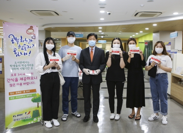 박승호 총장이 직접 나누어 준 간식을 받은 학생들이 즐거워하고 있다.