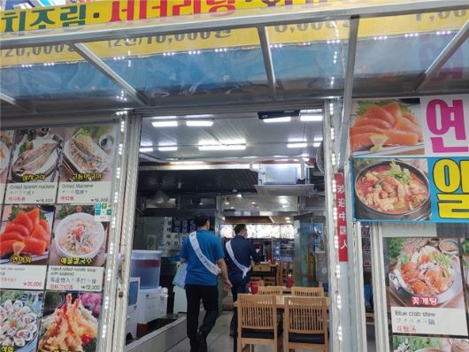 주민들에게 홍보물을 배부하여 올바른 쓰레기 배출에 대해 안내·계도 활동을 펼치고 있는 공무원, 환경미화원