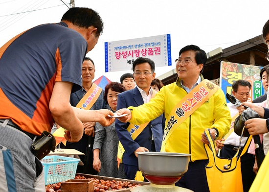 황룡시장에서 장성사랑상품권으로 물건을 구매하는 유두석 장성군수