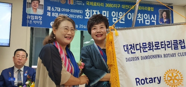 25일 가온 박미영 취임회장은 클럽사무실에서 대전다문화로타리클럽 8대회장 취임식에 효천 이정윤 이임회장으로 부터 클럽기를 전달 받고 있다./(사진=대전다문화로타리클럽)