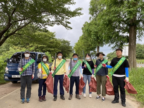 보성군, 득량면 환경기동대 덕산저수지 환경정화 활동을 기념하며 사진을 촬영하고 있다.